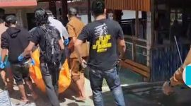 Petugas Polsek Air Hangat Timur bersama warga mengevakuasi jenazah lansia yang ditemukan di kamar mandi Pemandian Air Panas Sungai Medang, Senin (21/7/2025).