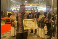 Kepala Dinas Kominfo Kota Sungai Penuh, H. Josrizal Helman, S.Si., Apt., saat menerima penghargaan Predikat Informatif KIP 2024 dari Gubernur Jambi.
