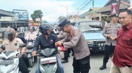 Kabag Ops Polres Kerinci AKP Yudi Stira membagikan bendera merah putih kepada pengendara di Kota Sungai Penuh, Selasa (5/8/2025).