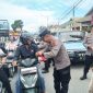 Kabag Ops Polres Kerinci AKP Yudi Stira membagikan bendera merah putih kepada pengendara di Kota Sungai Penuh, Selasa (5/8/2025).