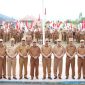 Bupati Kerinci Monadi menyerahkan bendera Merah Putih secara simbolis kepada perwakilan peserta pada upacara dan apel kerja di halaman Kantor Bupati Kerinci, Senin (11/8/2025)