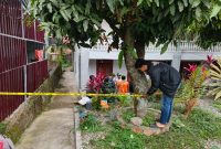 Polisi memasang garis polisi di sekitar halaman rumah warga untuk mengamankan lokasi kejadian. ( Foto Humas Polres Kerinci)

