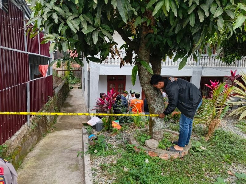 Polisi memasang garis polisi di sekitar halaman rumah warga untuk mengamankan lokasi kejadian. ( Foto Humas Polres Kerinci)  