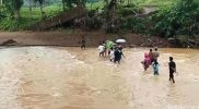 Warga Sukabumi memikul keranda jenazah menyeberangi Sungai Cikarang karena jembatan penghubung rusak diterjang banjir.