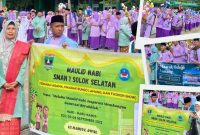 Pelajar SMAN 1 Solok Selatan berjalan beriringan membawa bungo lamang sambil menabuh rebana dan melantunkan sholawat.