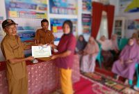 Kepala Desa Talang Lindung, Zulfajri, menyerahkan BLT September Rp300 ribu kepada salah satu warga penerima di kantor desa.