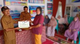 Kepala Desa Talang Lindung, Zulfajri, menyerahkan BLT September Rp300 ribu kepada salah satu warga penerima di kantor desa.