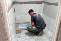 Koptu Edward dari Satgas TMMD ke-126 Kodim 0417/Kerinci memasang keramik pada fasilitas MCK di Desa Sungai Jernih, Kota Sungai Penuh.