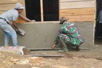 Sertu Gusnitar Jaya bersama anggota Satgas TMMD ke-126 Kodim 0417/Kerinci bergotong royong memplester rumah milik Yornel, warga Desa Sungai Jernih.