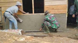 Sertu Gusnitar Jaya bersama anggota Satgas TMMD ke-126 Kodim 0417/Kerinci bergotong royong memplester rumah milik Yornel, warga Desa Sungai Jernih.