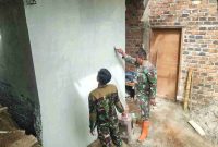 Anggota Satgas TMMD 126 Kodim 0417/Kerinci mengecat dinding MCK di Desa Sungai Jernih.