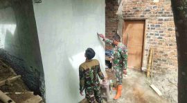 Anggota Satgas TMMD 126 Kodim 0417/Kerinci mengecat dinding MCK di Desa Sungai Jernih.