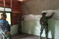 Anggota Satgas TMMD ke-126 Kodim 0417/Kerinci mengecat rumah bantuan di Desa Sungai Jernih.(Foto Humas Kodim)