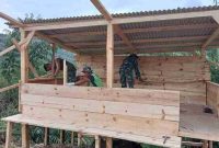 Prajurit TMMD ke-126 dan warga bangun pos kamling.( Foto Humas Kodim 0417 Kerinci)