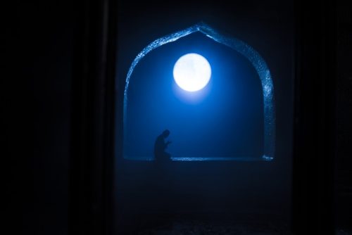 Seorang muslim menengadahkan tangan berdoa setelah menunaikan sholat witir sebagai penutup ibadah malam.
