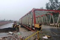 Sebuah jembatan baja terlihat terputus setelah bagian opritnya hanyut akibat banjir yang melanda wilayah Sumatera.