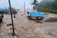 Warga mengevakuasi barang-barang dari rumah yang terendam banjir di Provinsi Catanduanes, Filipina, Minggu (9/11/2025).