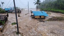 Warga mengevakuasi barang-barang dari rumah yang terendam banjir di Provinsi Catanduanes, Filipina, Minggu (9/11/2025).