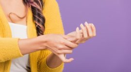 Seorang pria memegangi sendi kakinya karena nyeri akibat serangan asam urat.