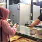 Pedagang menunjukkan logam mulia yang dijual di Toko Emas Amalia, Batang Hari.