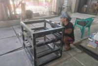 Hen Madura mengerjakan pesanan rak besi di bengkel las sederhana miliknya di Kota Sungai Penuh, tempat ia menafkahi dan membesarkan kedua anaknya seorang diri.