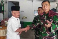 Personel Satgas TMMD 126 Kodim 0417/Kerinci berjabat tangan dengan warga usai salat berjamaah.