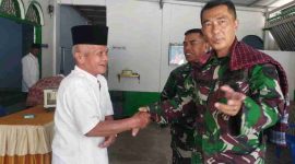 Personel Satgas TMMD 126 Kodim 0417/Kerinci berjabat tangan dengan warga usai salat berjamaah.
