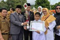Emrizal menyerahkan trofi dan sertifikat kepada salah satu penerima penghargaan pada peringatan HKN ke-61.