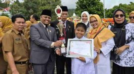 Emrizal menyerahkan trofi dan sertifikat kepada salah satu penerima penghargaan pada peringatan HKN ke-61.