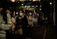 Orang-orang membawa bunga untuk memberikan penghormatan terakhir bagi korban kebakaran (Foto: AFP/PHILIP FONG)