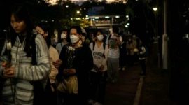Orang-orang membawa bunga untuk memberikan penghormatan terakhir bagi korban kebakaran (Foto: AFP/PHILIP FONG)