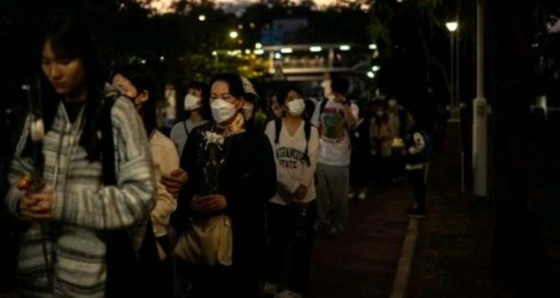 Orang-orang membawa bunga untuk memberikan penghormatan terakhir bagi korban kebakaran (Foto: AFP/PHILIP FONG)
