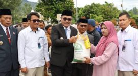 Wali Kota Sungai Penuh Alfin menyerahkan bantuan pangan kepada warga, didampingi Wawako Azhar Hamzah, Kepala Bulog, dan Kepala Dinas Ketahanan Pangan.