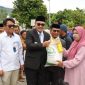 Wali Kota Sungai Penuh Alfin menyerahkan bantuan pangan kepada warga, didampingi Wawako Azhar Hamzah, Kepala Bulog, dan Kepala Dinas Ketahanan Pangan.