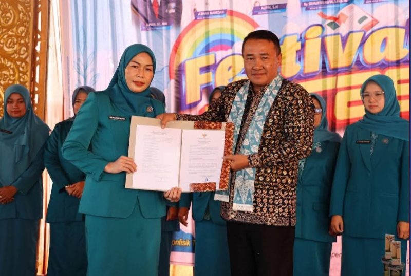 Wali Kota Sungai Penuh, Alfin, SH, menyerahkan SK pengukuhan kepada Bunda Literasi Kota Sungai Penuh, Sri Kartini Alfin, S.Kep., NS, pada Festival Literasi 2025.