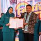 Wali Kota Sungai Penuh, Alfin, SH, menyerahkan SK pengukuhan kepada Bunda Literasi Kota Sungai Penuh, Sri Kartini Alfin, S.Kep., NS, pada Festival Literasi 2025.