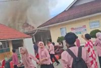 Asap terlihat keluar dari salah satu ruangan SMKN 5 Kerinci saat kebakaran terjadi.
( Foto siasat info)