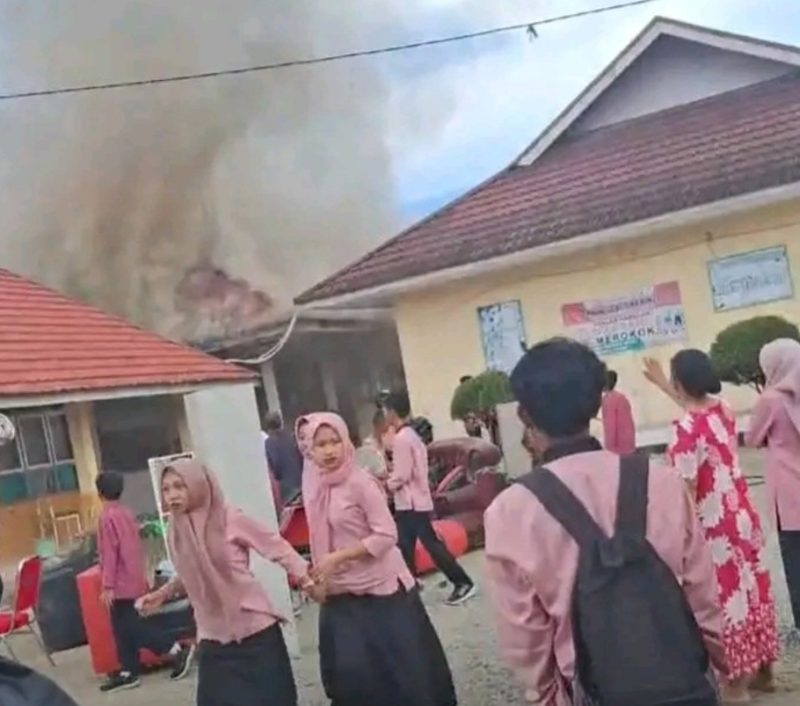 Asap terlihat keluar dari salah satu ruangan SMKN 5 Kerinci saat kebakaran terjadi.
( Foto siasat info)
