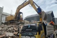 Pekerja membongkar sisa bangunan rumah Ahmad Sahroni di Tanjung Priok menggunakan ekskavator (Kompas Megapolitan)