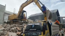 Pekerja membongkar sisa bangunan rumah Ahmad Sahroni di Tanjung Priok menggunakan ekskavator (Kompas Megapolitan)