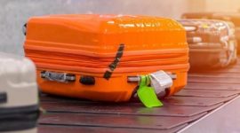 Koper bertanda fragile yang keluar lebih awal di konveyor bagasi bandara.