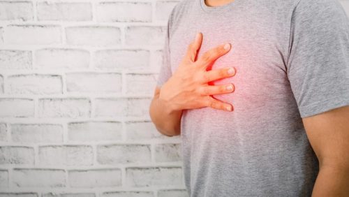Seorang pria memegang bagian dada kiri saat merasakan nyeri yang bisa menjadi salah satu tanda gangguan jantung.