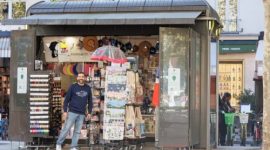 Petugas kios koran di dekat Accor Arena melayani wisatawan yang mencari informasi tentang destinasi populer di Paris.