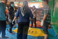 Petugas gabungan tengah memeriksa dan menata kantong jenazah korban banjir bandang di Puskesmas Kayu Tanam, Padang Pariaman.