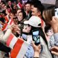 Presiden Prabowo Subianto menerima bunga dari anak-anak Indonesia saat tiba di hotel di Sydney, disaksikan para diaspora dan pejabat pemerintah.