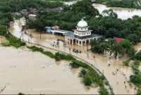 Foto udara pengendara melintasi jalan nasional Medan-Banda Aceh yang terendam banjir di Desa Peuribu, Arongan Lambalek, Aceh Barat, Aceh, Kamis (27/11/2025). (Sumber: Syifa Yulinnas/Antara)