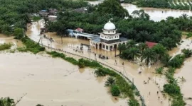 Foto udara pengendara melintasi jalan nasional Medan-Banda Aceh yang terendam banjir di Desa Peuribu, Arongan Lambalek, Aceh Barat, Aceh, Kamis (27/11/2025). (Sumber: Syifa Yulinnas/Antara)