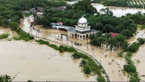 Foto udara pengendara melintasi jalan nasional Medan-Banda Aceh yang terendam banjir di Desa Peuribu, Arongan Lambalek, Aceh Barat, Aceh, Kamis (27/11/2025). (Sumber: Syifa Yulinnas/Antara)