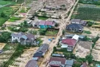Foto udara menunjukkan permukiman warga dan lahan pertanian yang terdampak banjir bandang dan aliran lumpur akibat bencana hidrometeorologi di Sumatra, akhir November 2025.