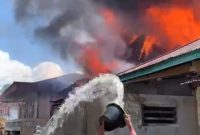 Warga berusaha memadamkan api yang melahap dua rumah di Desa Tanjung Mudo Penawar, Kerinci.